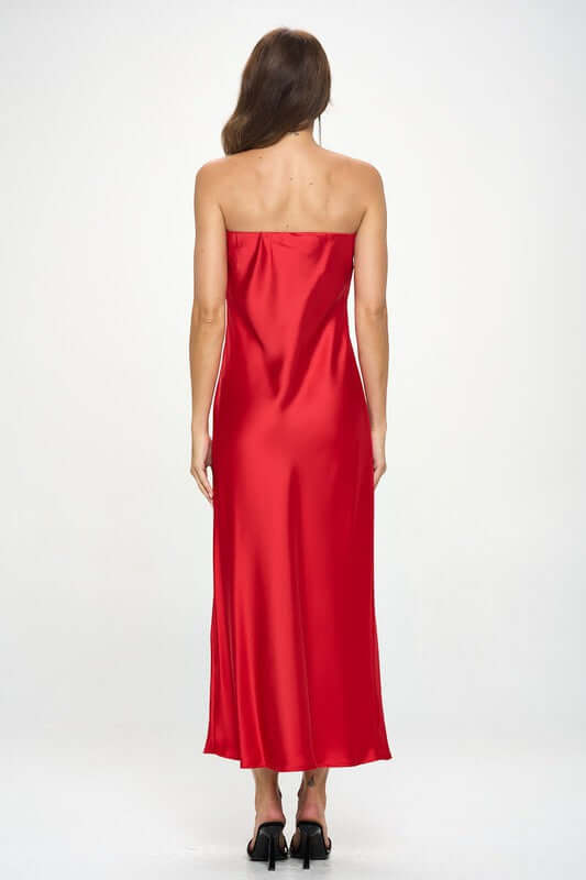 Woman wearing a red silky satin tube draped maxi dress, sleeveless and strapless, made in the USA.