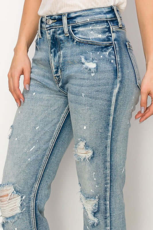 High rise distressed straight fray hem jeans with bleach effect and frayed details for an edgy style.