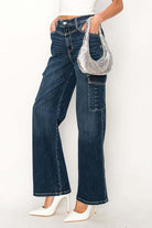 High rise wide leg jeans styled with a silver handbag and white heels, showcasing modern casual fashion.