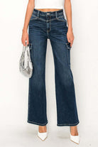 High Rise Wide Jeans with solid pattern, styled with a high-rise waist and wide leg silhouette, paired with white heels.