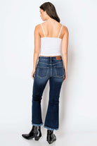 Woman wearing Corset High Rise Crop Flare Jeans with a white top, showcasing a flattering silhouette from the back.