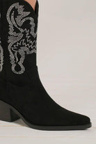 Black point toe boots with rhinestone detailing for a glamorous and sophisticated look.