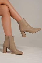 Stylish beige PU leather block heel boots with side zippers, perfect for any outfit.